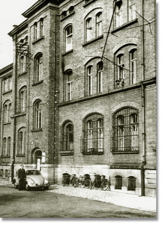 Historisches Foto der Orthopädischen Versorgungsstelle Würzburg mit Person und VW-Käfer im Vordergrund