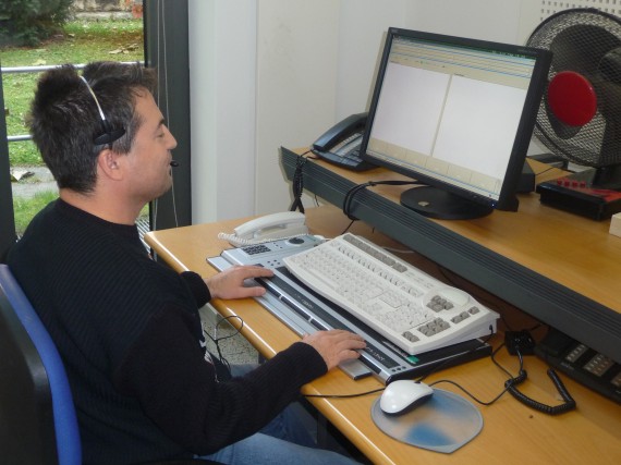 Ein sehbehinderter Mitarbeiter der Telefonzentrale des ZBFS an seinem speziell angepassten Arbeitsplatz beim Bedienen einer Braille-Tastatur