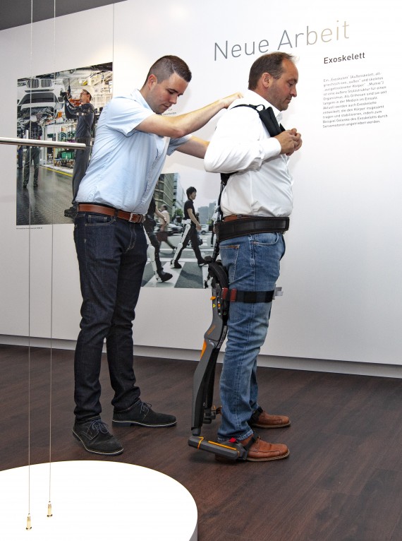 Ein fachlich geschulter Mitarbeiter des ZBFS legt einem Ausstellungsbesucher eine „Noonee“ Exoskelett-Sitzhilfe zur Selbsterfahrung an