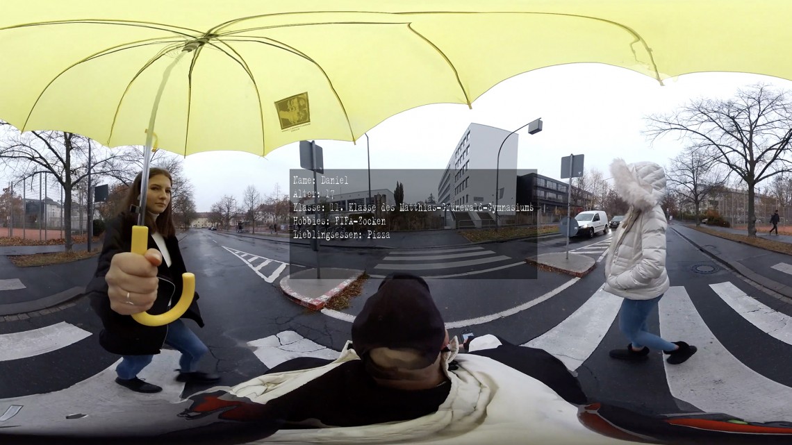 Ausschnitt aus einem 360 Grad Video mit der Darstellung des Schulwegs vom öffentlichen Raum bis zum Sitzplatz im Klassenzimmer aus der Perspektives eines Rollstuhlfahrer - Standbild 1