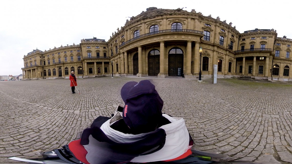 Ausschnitt aus einem 360 Grad Video mit der Darstellung des Besuchs der Würzburger Residenz aus der Perspektive eines Rollstuhlfahrers vom Vorplatz bis zum berühmten Tiepolo Deckenfresko und von verschiedenen Seheinschränkungen - Standbild 1
