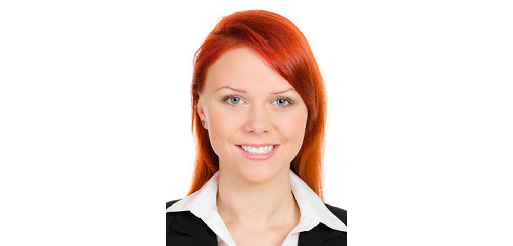 Gesicht einer lächelnden jungen Frau mit langen rötlichen Haaren