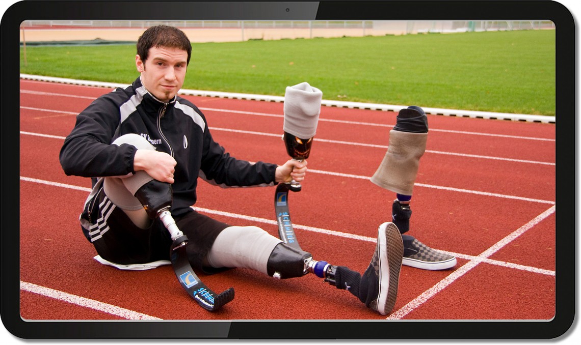 Monitor mit Video einer beidseitig unterschenkelamputierten Person beim Sport mit Sprungfeder-Prothesen aus Karbon Verbundwerkstoff